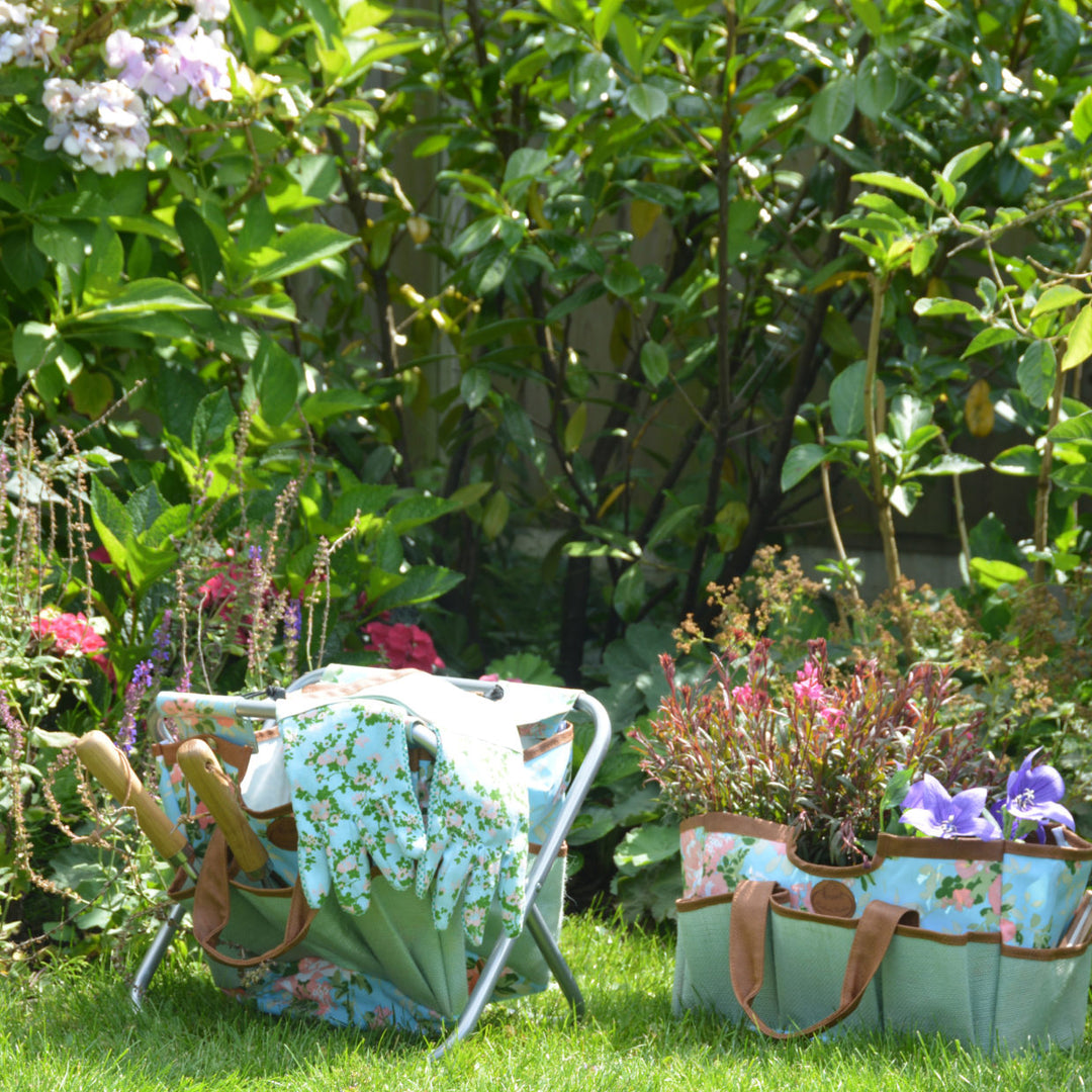 Floral print plant bag next to floral print stool in a garden with wildflowers