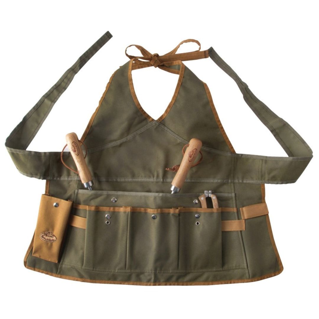 A khaki green ladies apron with many pockets for gardening tools on the front, which ties with a thick band around the waist and with thinner ties behind the neck