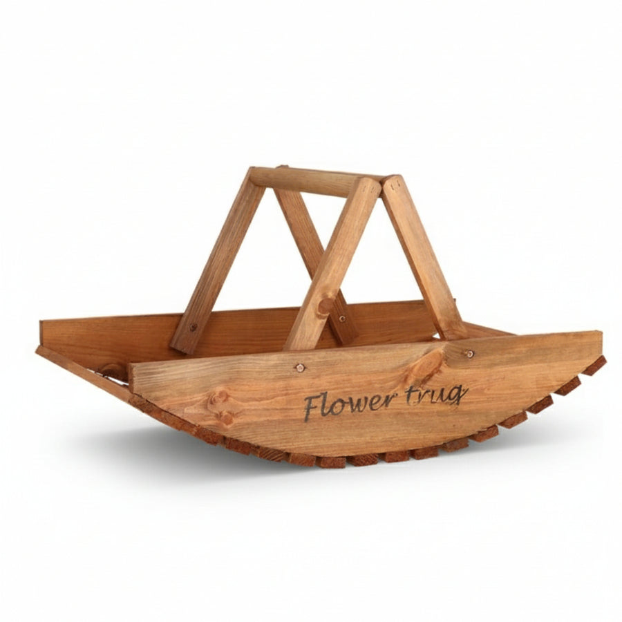 A basket made of solid wood pieces with a curved, slatted wooden base and the words 'Flower trug' in flowy handwriting engraved on the side