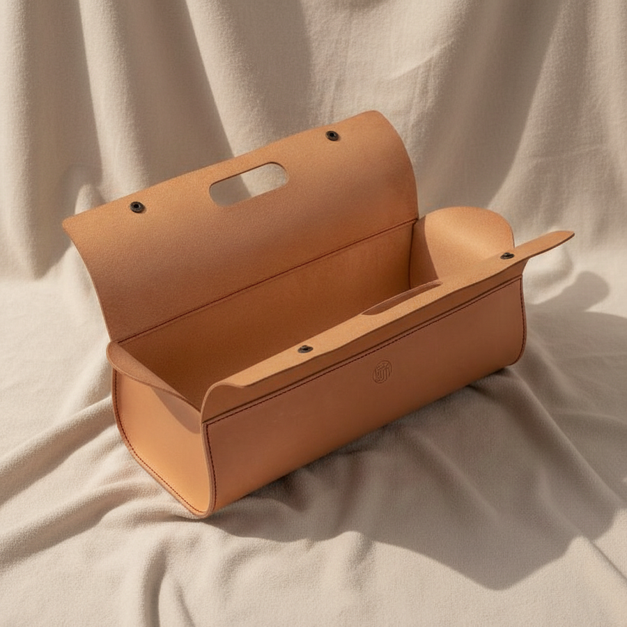 Brown leather Niwaki tool bag on a beige fabric background