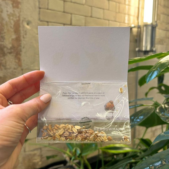 Image showing the inside of the card, with some instructions printed on the card and a small packet of bird seed stapled inside