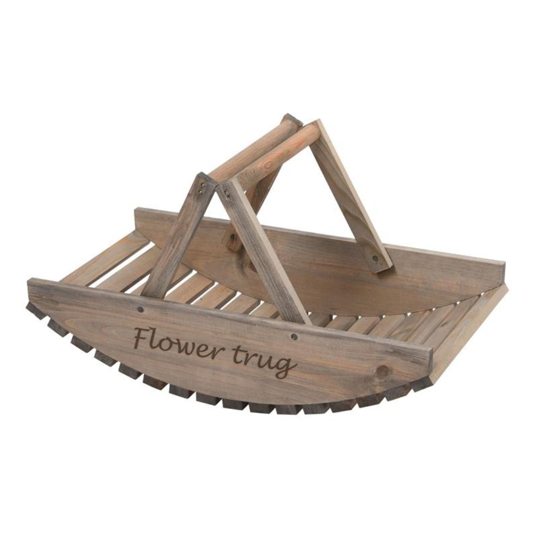 A basket made of solid wood pieces with a curved, slatted wooden base and the words 'Flower trug' in flowy handwriting engraved on the side