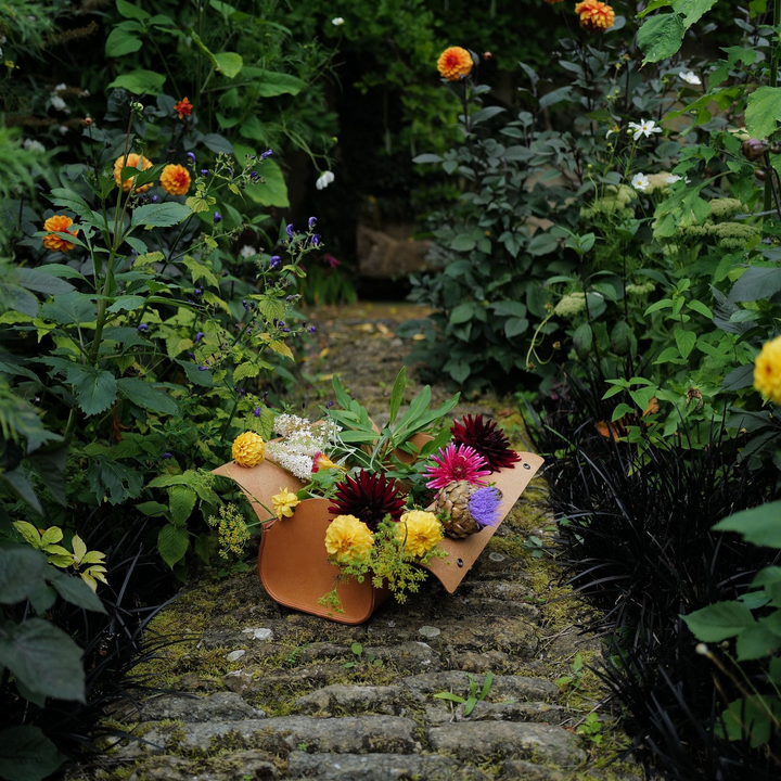 Floral arrangement in Niwaki too bag on a stone path surrounded by greenery